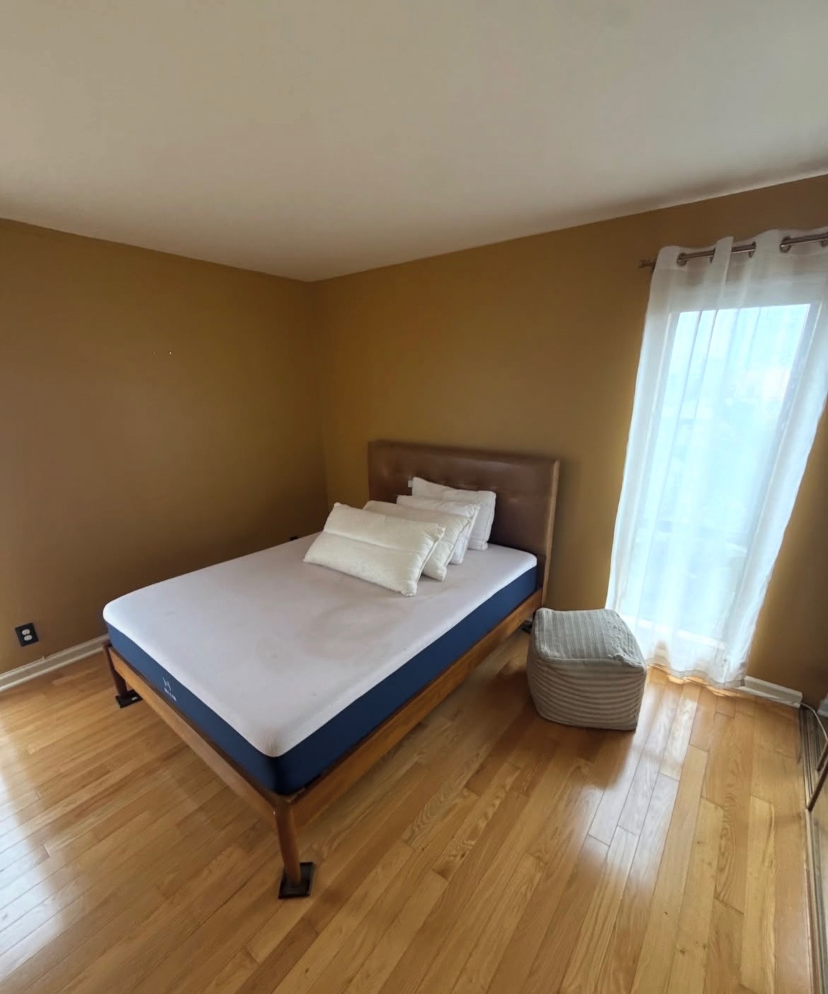Guest bedroom with a bed frame, mattress and ottoman before Greer Hauling removed them