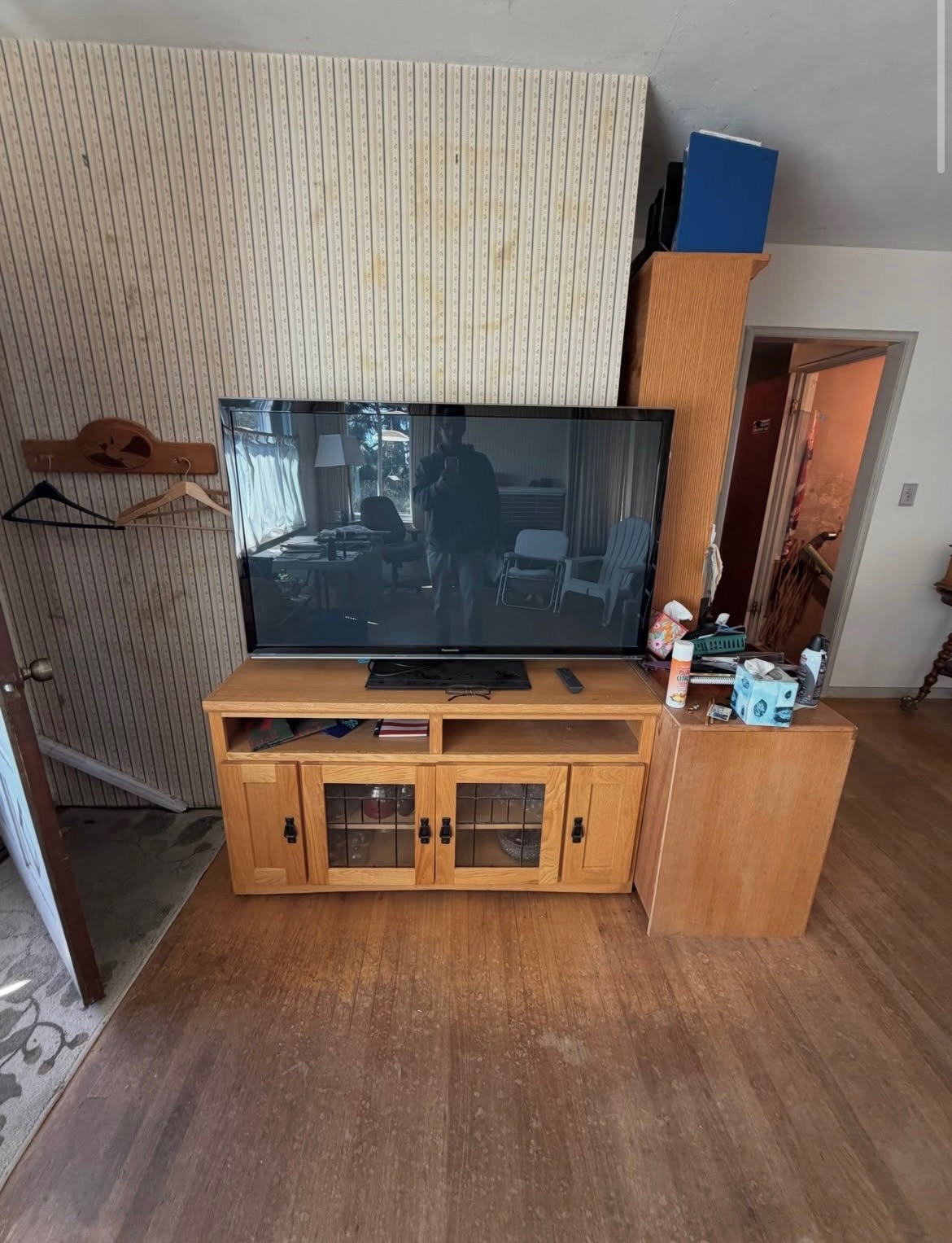 Living room with an old TV, entertainment center and clutter before removal